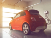 Fiat 500e obok terminalu garażowego firmy AeroVironment