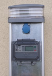 Słupek wolnostojący do ładowania z jednym gniazdkiem i oświetleniem, firmy AMPS